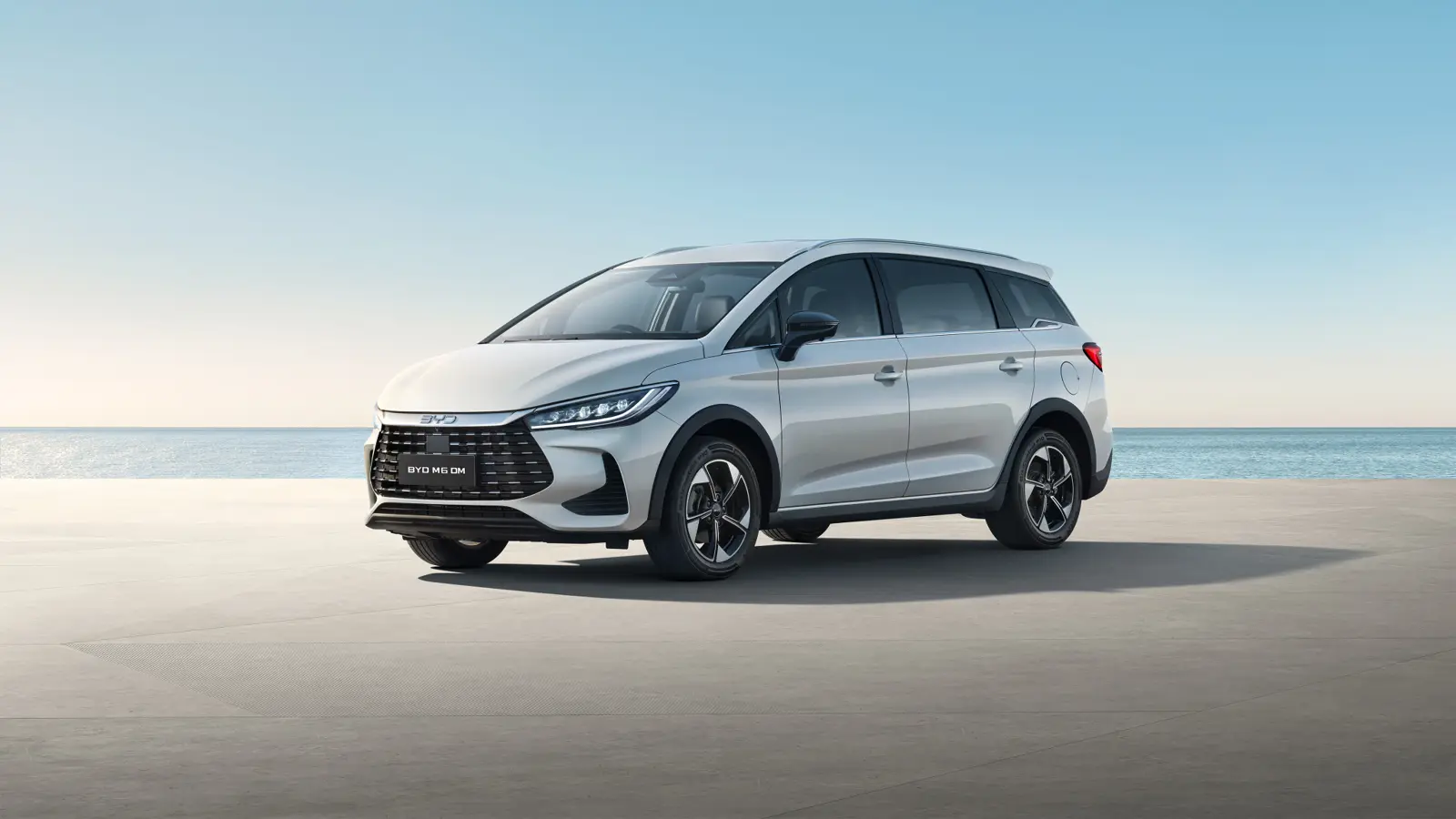 BYD M6 DM, MPV keluarga putih dengan DM Technology, terparkir di tepi pantai